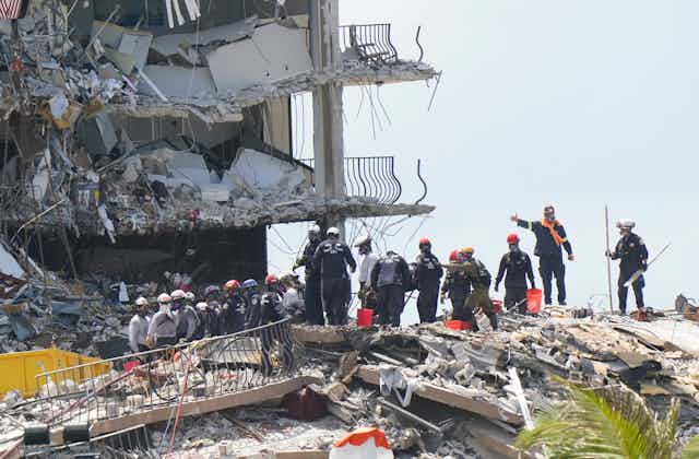 Rescue workers standing on rubble. 
