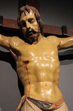 Sculpture of Christ on the cross showing arm hinges.
