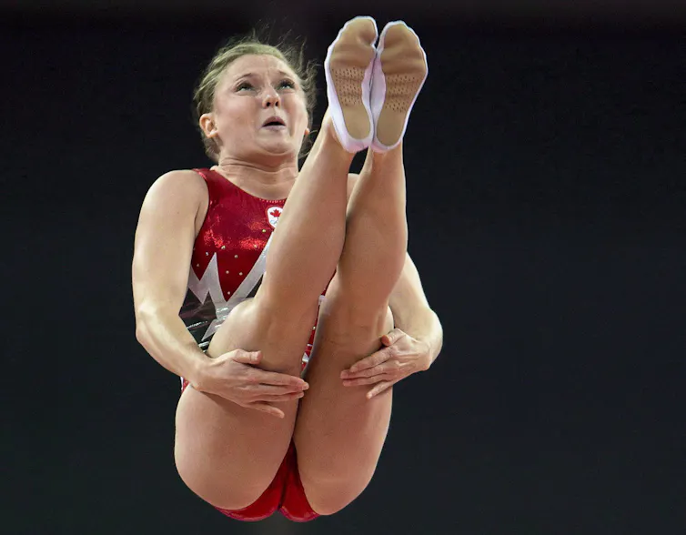 Trampoline athlete Rosie MacLennan grips her thighs during a jump in her routine