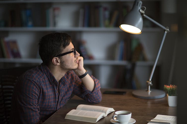 man with book looking off into distance