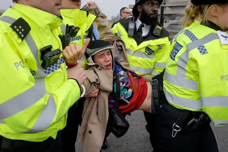 A protester being carried by police