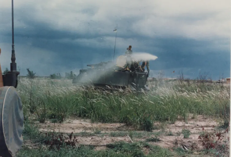 People spraying something in a field