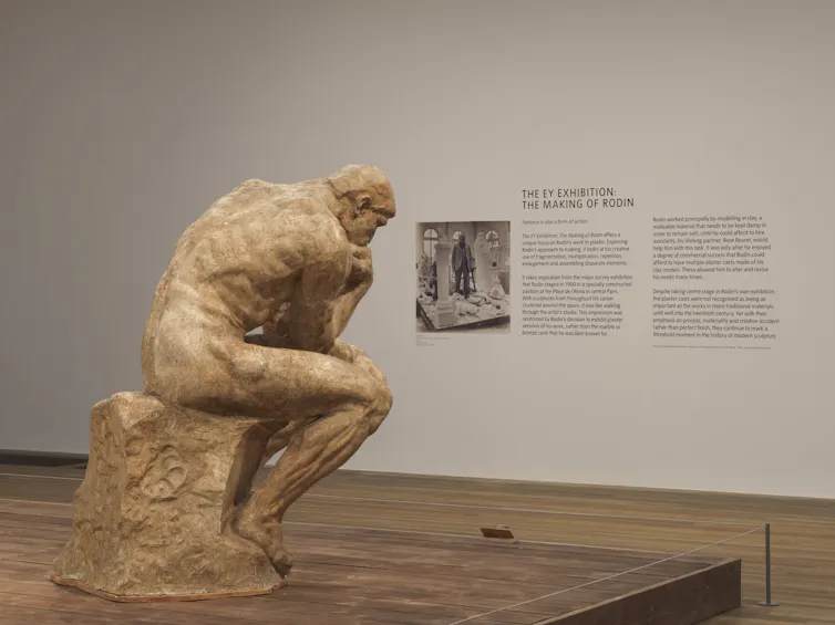 The Thinker statue in a gallery space.