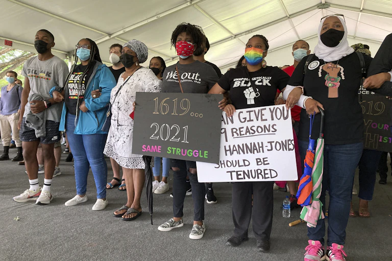 A group of people demonstrating in a large tent to demand Nikole Hannah-Jones be awarded tenure.