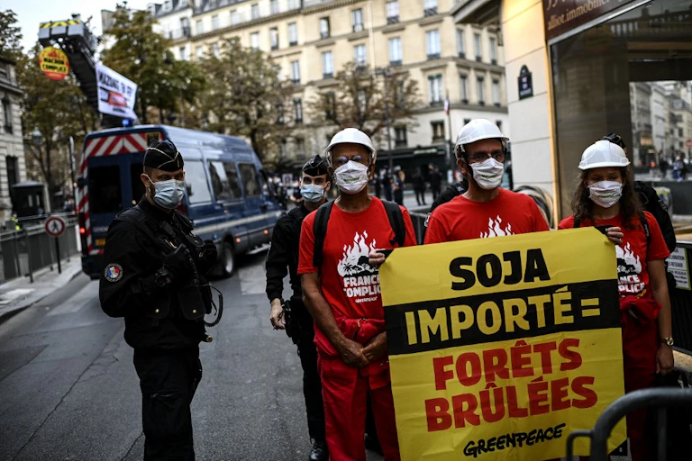 Manifestants portant une affiche de Greenpeace : « Soja importé = Forêts brûlées. »