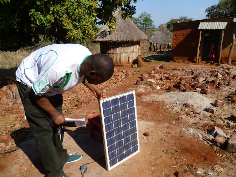 A person inspects a solar panel