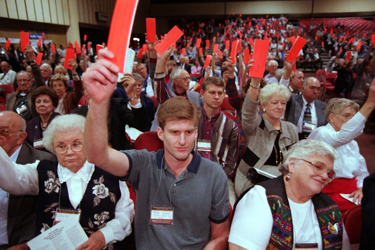 Voters raise their orange ballots to reject the Southern Baptist Convention's call for women to ``submit graciously'' to their husbands, during the Baptists General Convention of Texas held in El Paso, Texas. November 9,1999