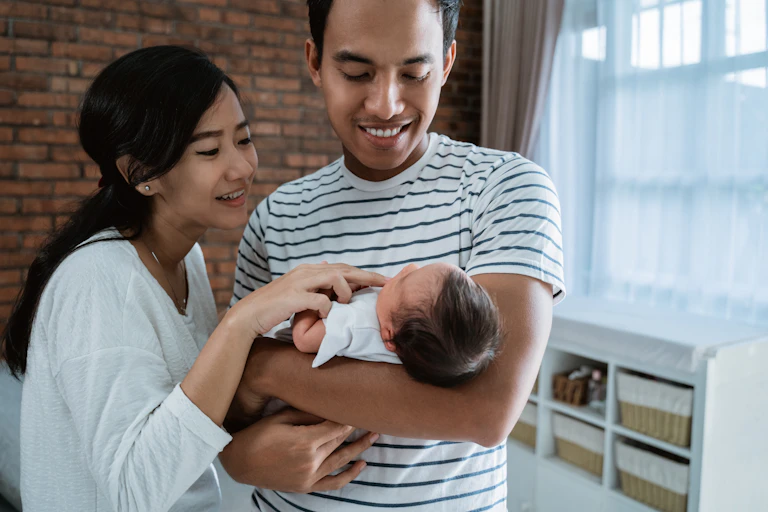Parents hold a newborn baby in their arms