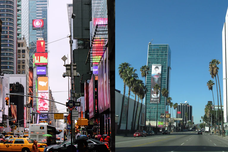 On the left, skyscrapers extending out of the frame surround a street full of traffic, billboards and neon signs line the street; on the right, a theater and several tall office buildings interspersed with tall palm trees line a wide boulevard