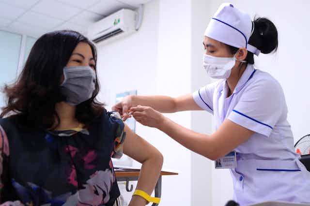Health-care worker giving someone a COVID vaccine