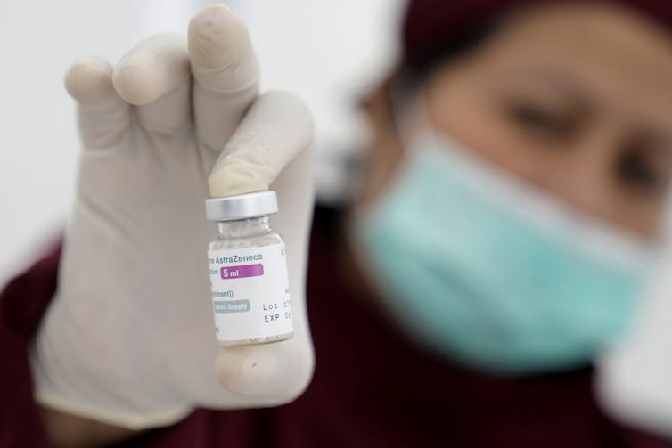 Health-care worker holding a vaccine vial