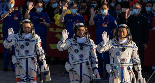 Image Chinese astronauts Tang Hongbo, Nie Haisheng, and Liu Boming during ceremony before heading to Tiangong.