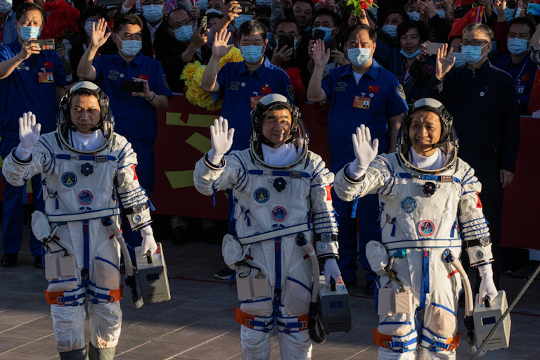 Image Chinese astronauts Tang Hongbo, Nie Haisheng, and Liu Boming during ceremony before heading to Tiangong.
