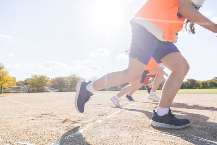 Students lined up at the starting line of a running track.