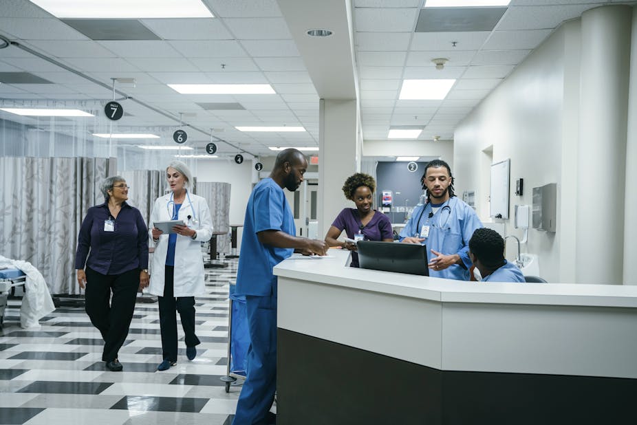 A group of doctors and nurses chatting in hospital.