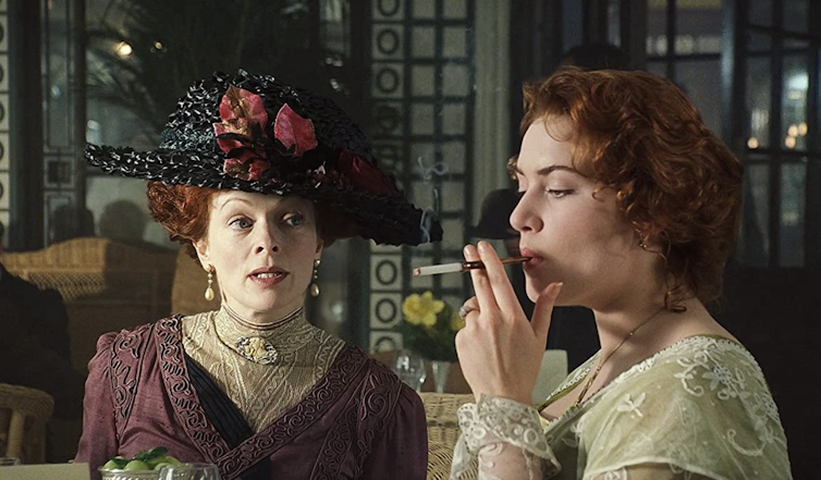 Two women in period costume, one smoking