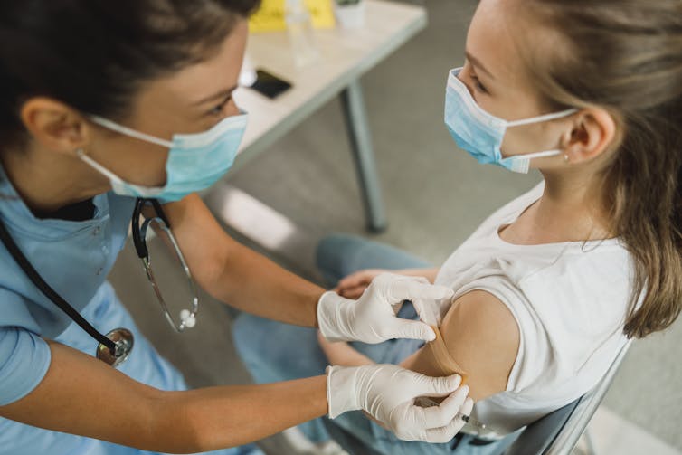 A young girl gets a vaccine.