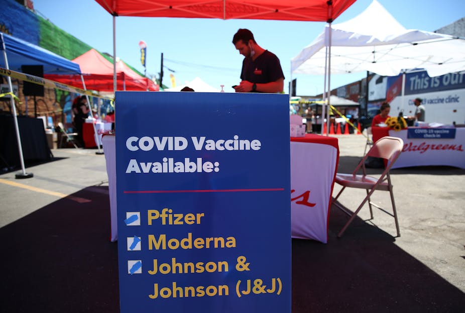 Sign at outdoor booth displays the types of COVID-19 vaccination doses available