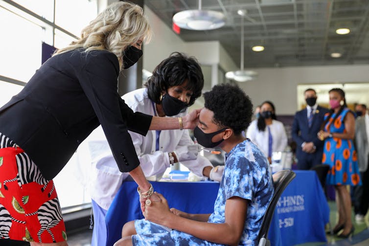 U.S. First Lady Jill Biden gives comfort to a patient at a vaccination clinic