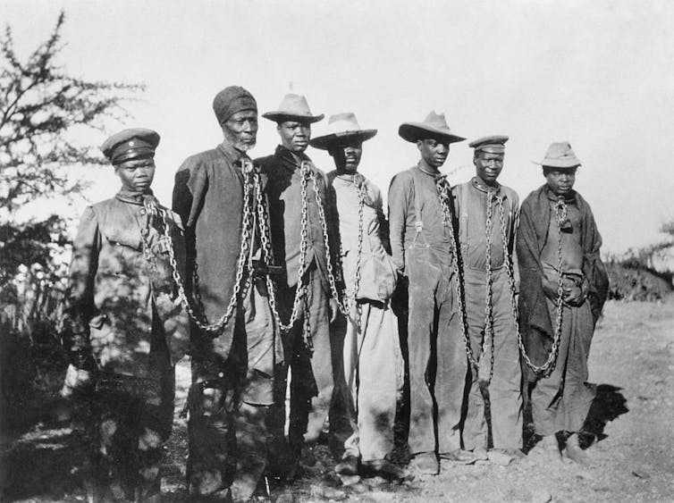 A photo from 1904/5 showing Herero captives in chains.