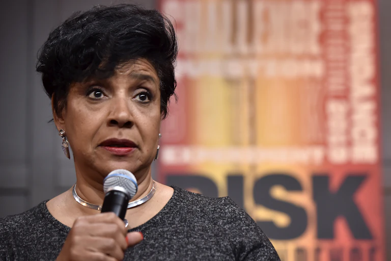A woman speaks through a microphone.