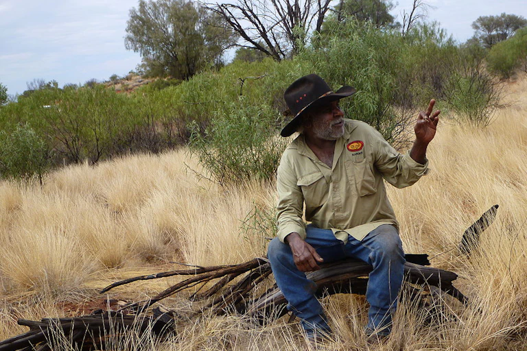 Ranger David Wongway sitting on a log.