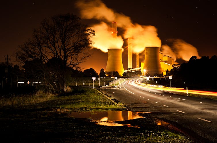 Coal-fired power station at the end of a road, at night