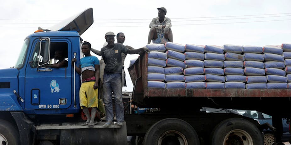 Men standing on a truck loaded with bags
