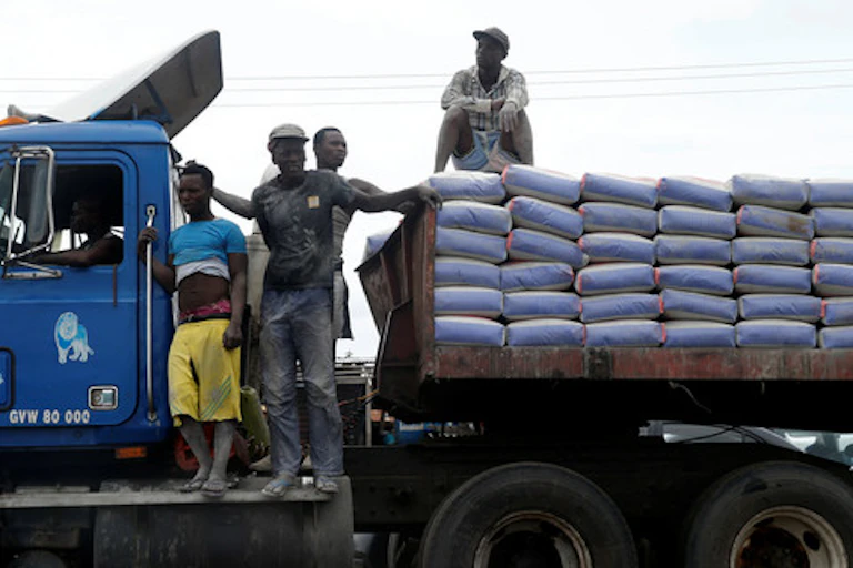 Men standing on a truck loaded with bags