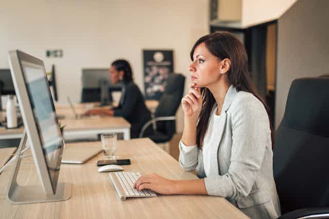 Woman in her 40s looks at her computer.