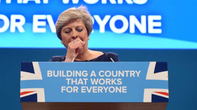 Theresa May, then the UK prime minister, coughs uncontrollably during a speech at the Conservative Party conference in October 2017.