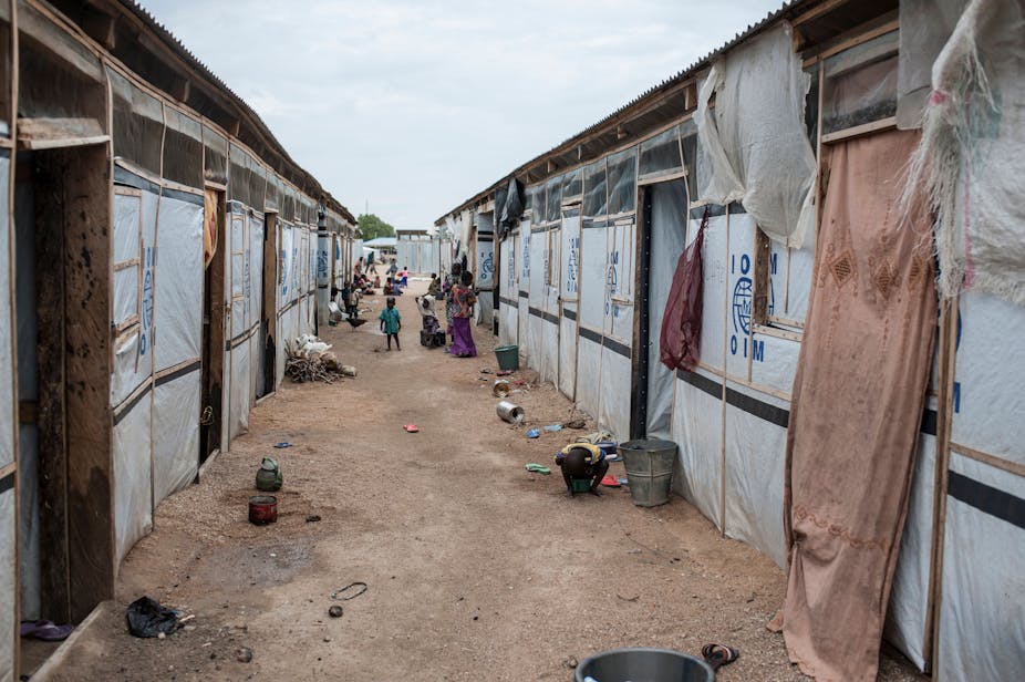 People stand in an alleyway in one of the IDP (Internally Displaced People) camps in Pulka on August 1, 2018.