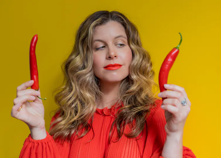 Girl choosing whether to add a hot chilli to a meal