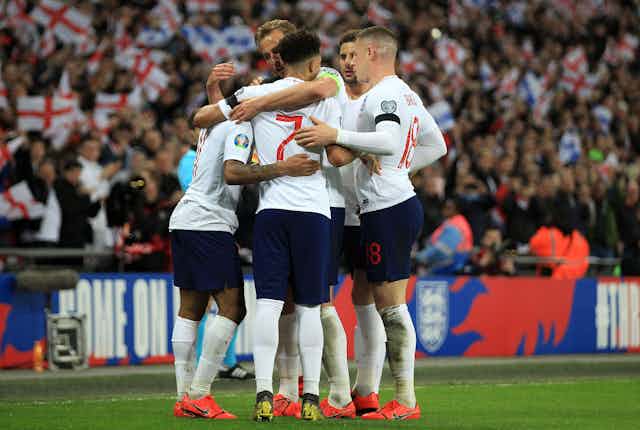 Five of England's players embrace after scoring during a qualifying Euros match