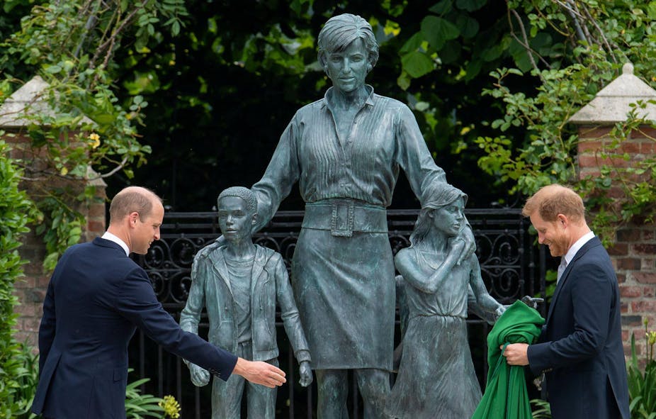  Princes William and Harry stand in front of a statue to their mother, Diana, Princess of Wales.