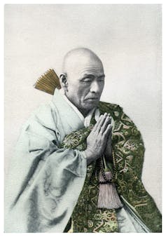 A vintage photograph of a Buddhist priest in repose.