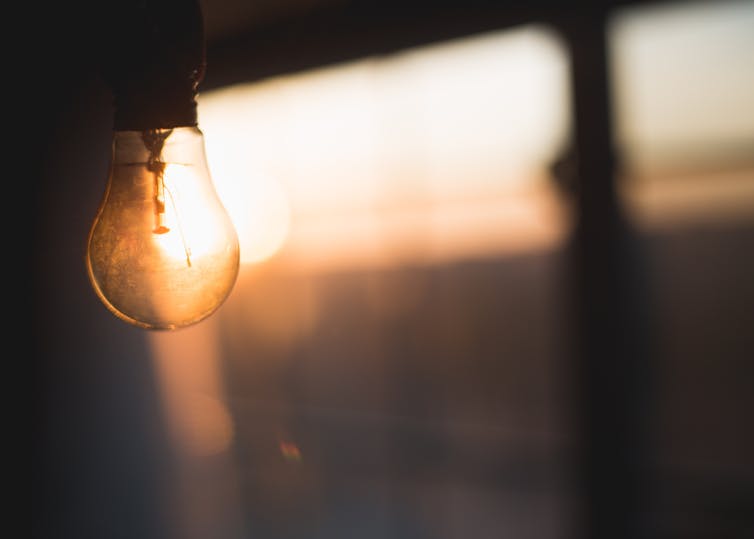 A light bulb against a pink sky.