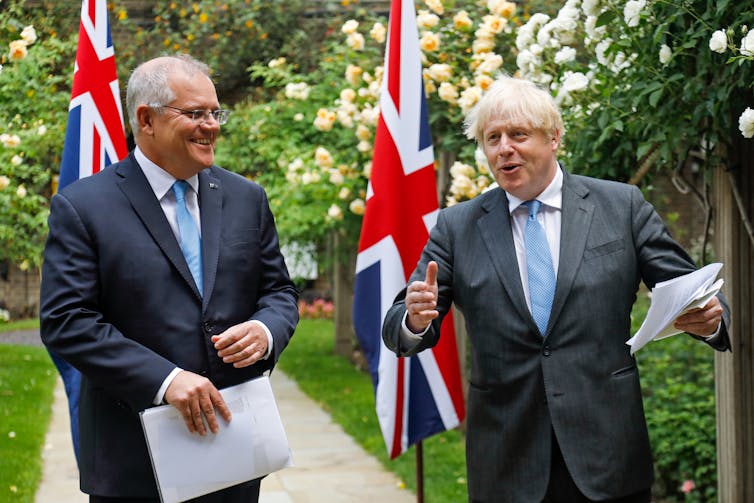 Scott Morrison and Boris Johnson in a garden with their national flags
