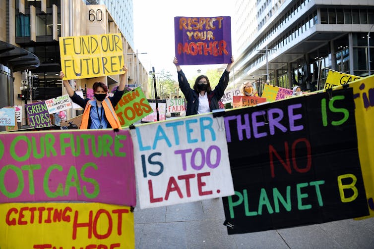 People hold protest signs