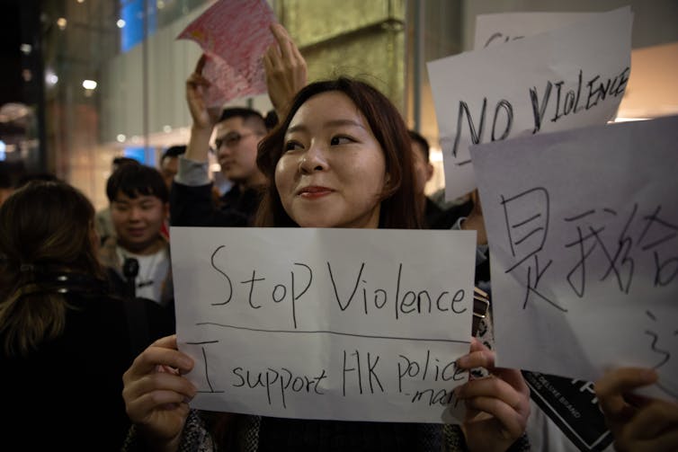 A protestor in Sydney holding up sign saying 