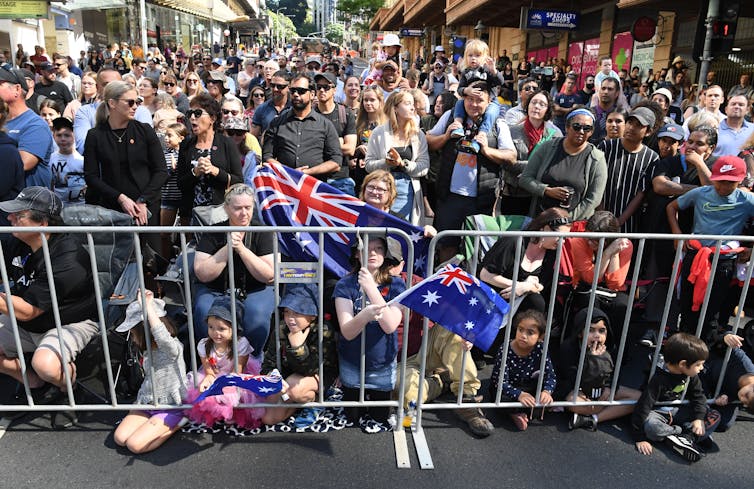 Crowds wait for an Anzac Day march.