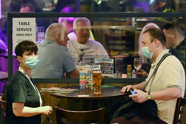 People wearing masks in a pub offering table service
