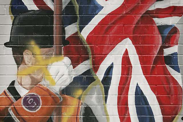 A defaced mural showing a member of the Orange Order is seen in Loyalist area of East Belfast.