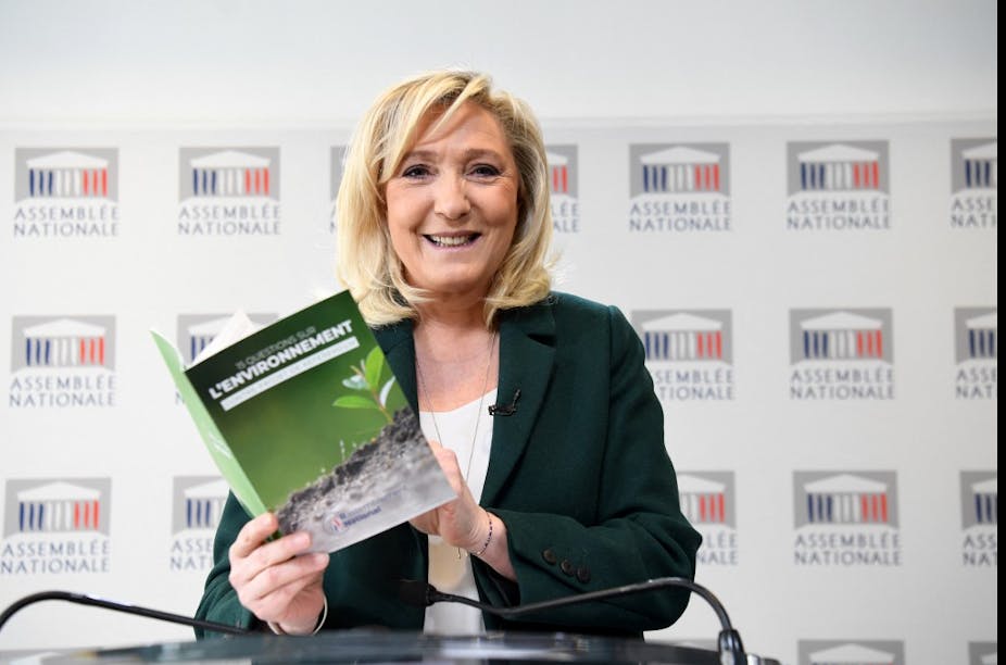 Marine Le Pen tient  à la main une brochure sur sa contre-proposition au projet d'amendement constitutionnel incluant le devoir de lutter contre le changement climatique, le 9 mars 2021.