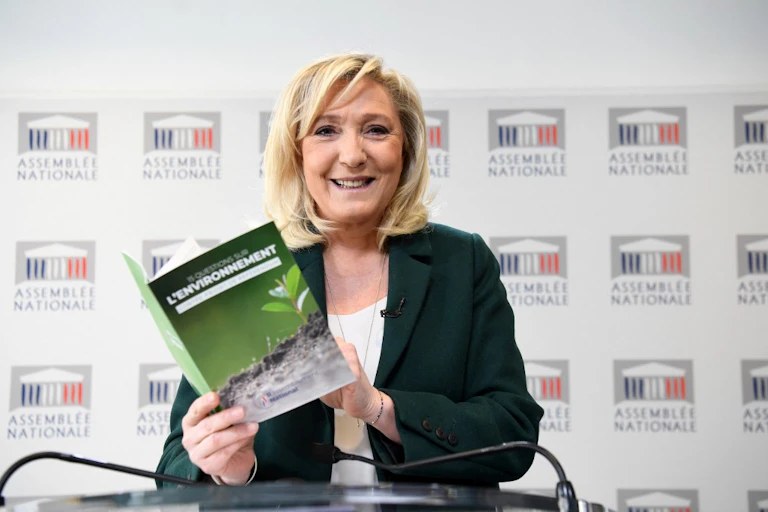 Marine Le Pen tient à la main une brochure sur sa contre-proposition au projet d'amendement constitutionnel incluant le devoir de lutter contre le changement climatique, le 9 mars 2021.