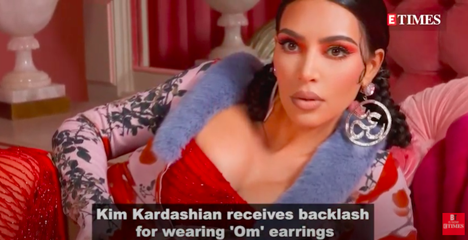 American reality TV star  Kim Kardashian wearing earrings patterned from the sacred Hindu Om during a photoshoot.