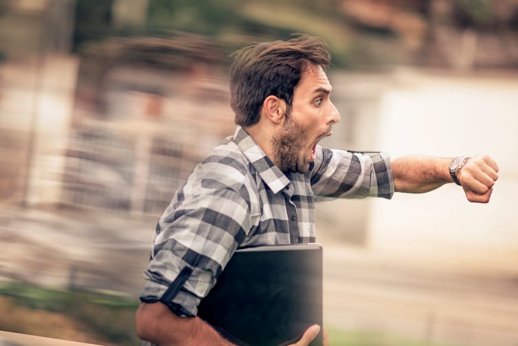 Panicked man runs with his computer under his arm