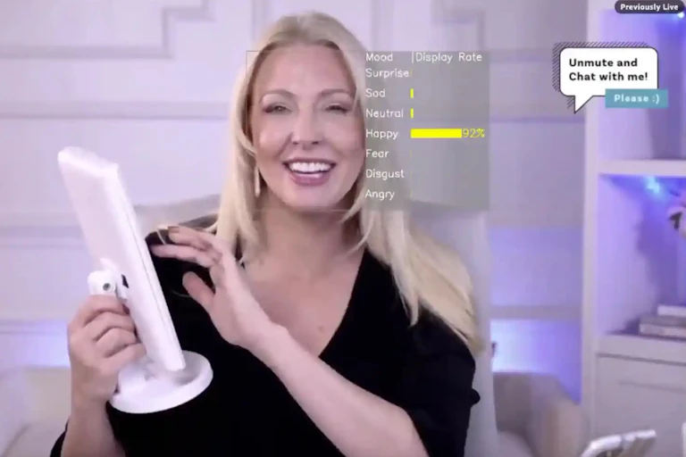 A woman smiles as she holds a screen and prepares to touch it with her other hand. A heads up display is overlaid near her face with the emotion of 'happy' highlighted.
