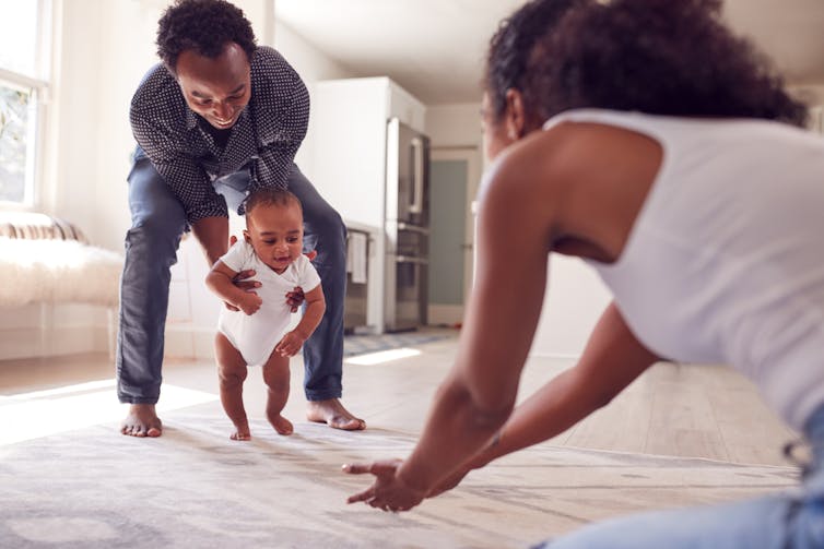 Parents playing with their new child on a bed