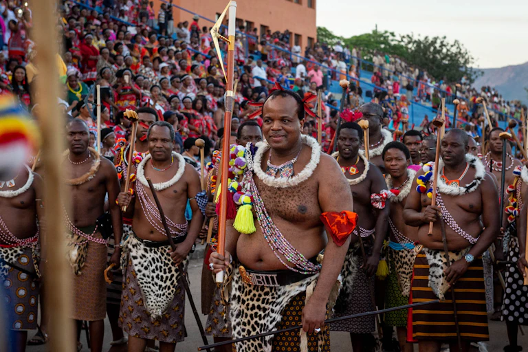 Men in traditional Swazi attire on a walkabout a stadium stadium.